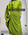 Elegant woman in a gold Show Stopper Boubou with draped detailing, posing gracefully at an outdoor event.