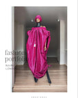 Pink off-shoulder boubou dress with black grid pattern, paired with a matching headwrap, displayed on a mannequin against a black paneled wall.