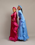 Women wearing the Ola Buubu satin gowns  with ruffle edges, long sleeves, high neckline, and matching headwraps.
