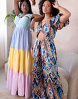 Model wearing multicolored open cut silk jumpsuit with puff sleeves and wide-leg design.
