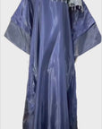Woman wearing a shiny metallic blue-green cupped chain dress with loose sleeves and embellished neckline.
